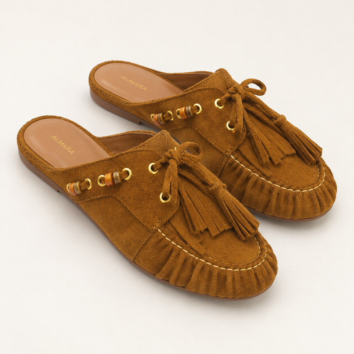 Mules Capri en carnaza con borlas y herrajes