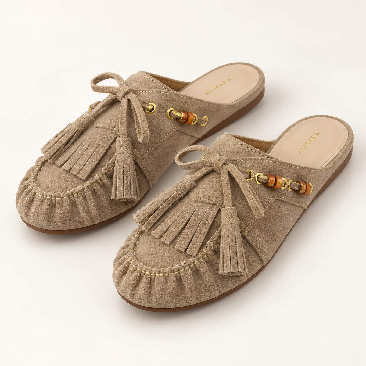 Mules Capri en carnaza con borlas y herrajes