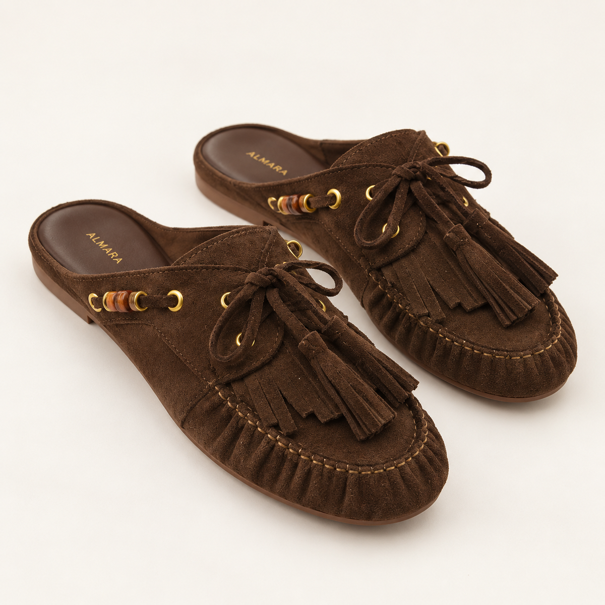 Mules Capri en carnaza con borlas y herrajes