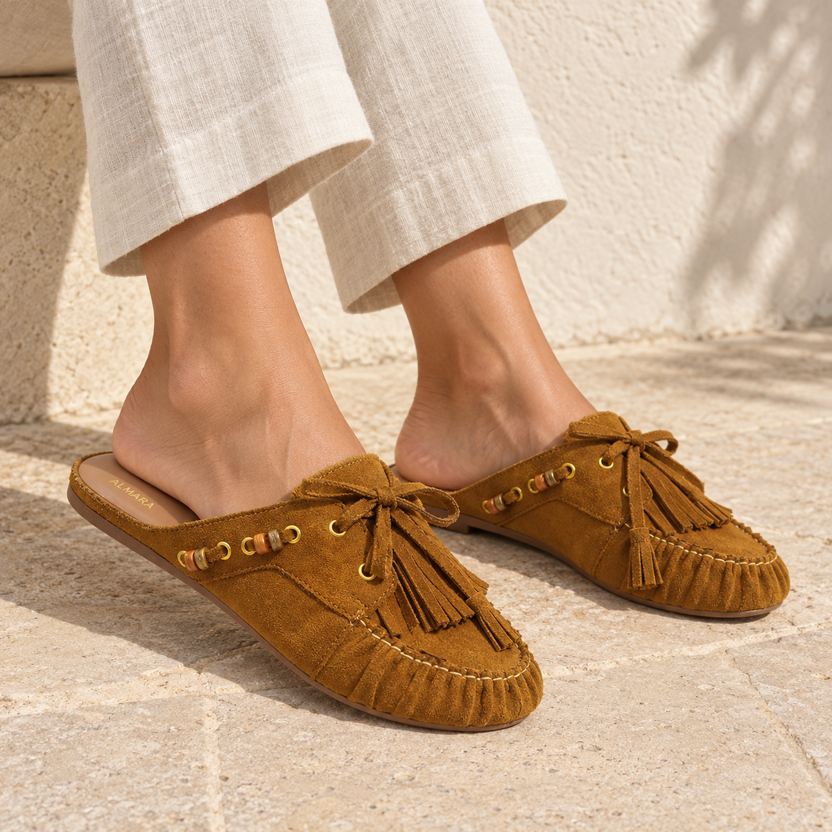 Mules Capri en carnaza con borlas y herrajes