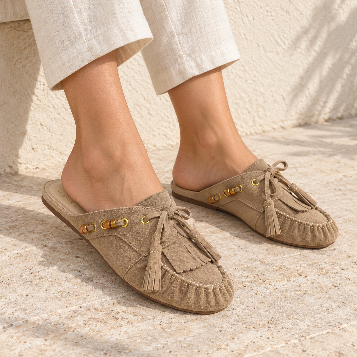 Mules Capri en carnaza con borlas y herrajes