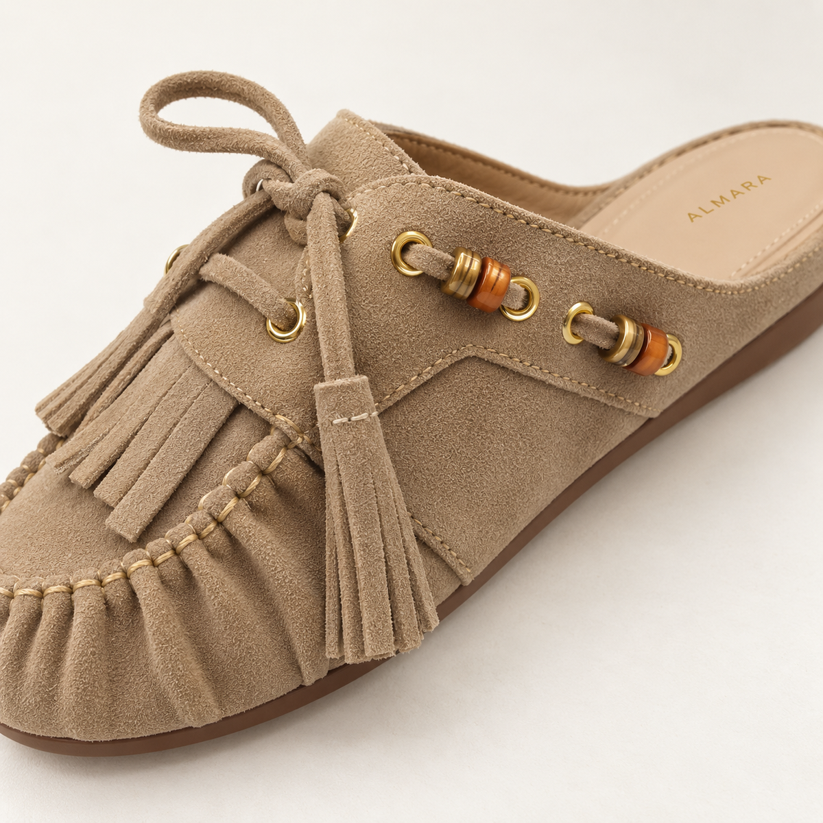 Mules Capri en carnaza con borlas y herrajes