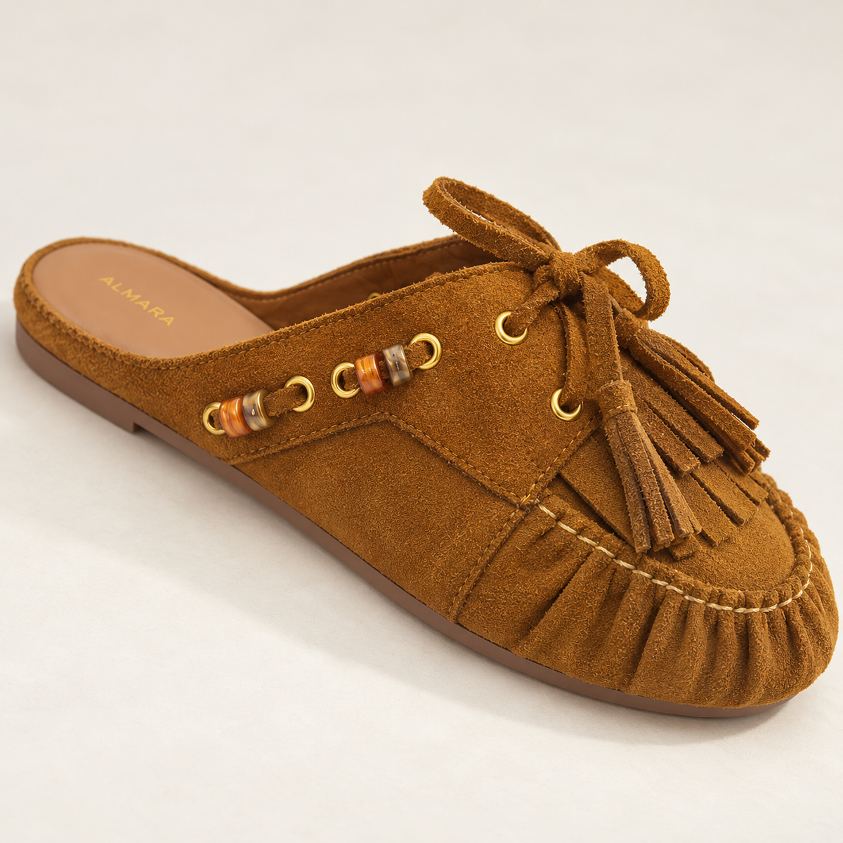 Mules Capri en carnaza con borlas y herrajes