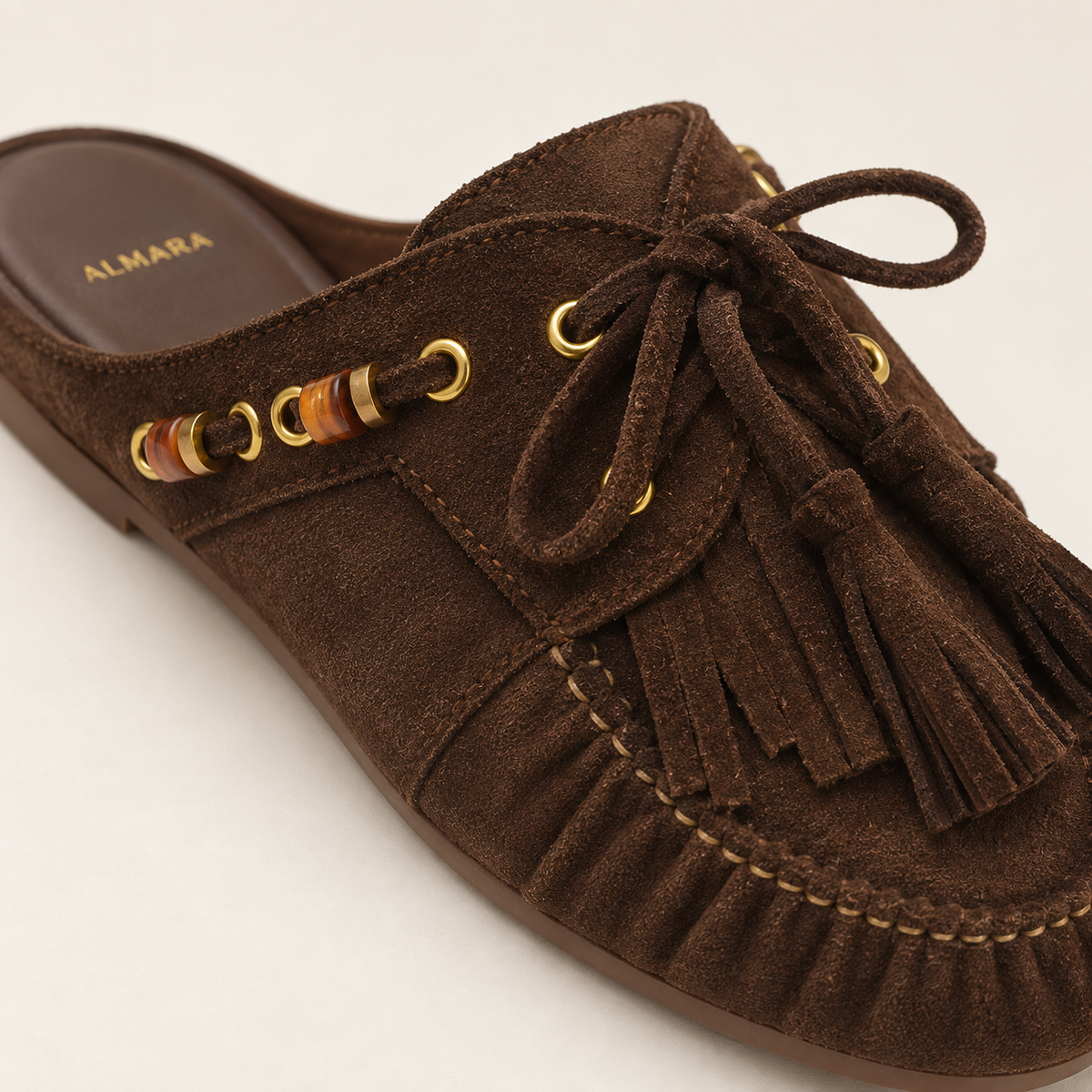 Mules Capri en carnaza con borlas y herrajes